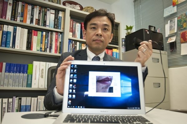 Prof Cheung Yiu-ming demonstrates using the world’s first “lip-password” technology, which can provide double security in identity authentication.