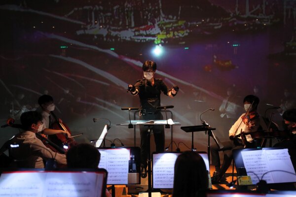 Professor Johnny Poon puts on sensors to conduct the performance of the Symphony Orchestra and the AI virtual choir.