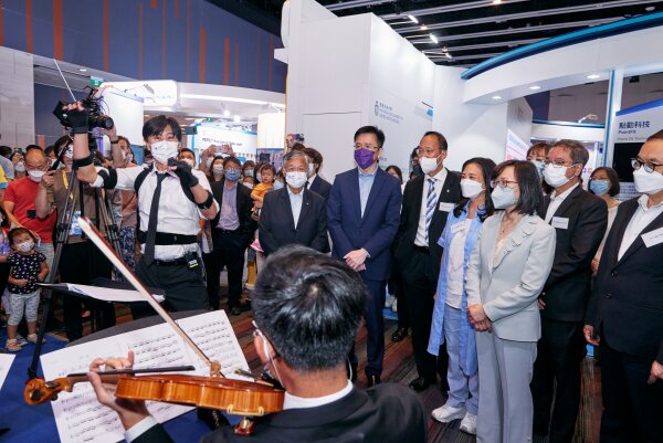 Professor Sun Dong, Secretary for Innovation, Technology and Industry (front row, 3rd left); and Ms Rebecca Pun, Commissioner for Innovation and Technology (front row, 1st right) of the HKSAR Government visit HKBU’s pavilion to enjoy a creative art performance presented jointly by HKBU musicians and AI artists.