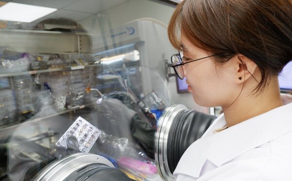 浸大物理系博士生郝明偉同學正在展示她製備的鈣鈦礦太陽能電池。