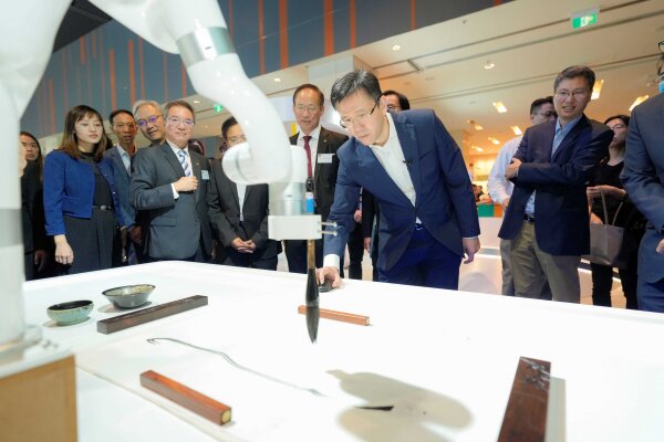 Professor Sun Dong, Secretary for Innovation, Technology and Industry (2nd right) accompanied by Professor Alexander Wai, President and Vice-Chancellor (3rd right) experiences real-time art creation using the calligraphy robot system.