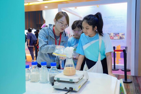 学生参观浸大展馆，了解利用细菌将废弃食用油和其他有机残余物转化为环保生物塑胶。
