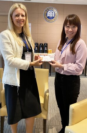 (left) Ms Tucker receives a souvenir from (right) Professor Cheung.