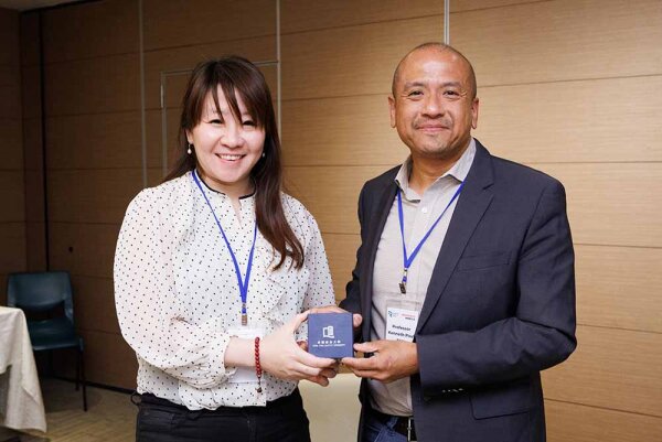 (Left) Professor Christy Cheung, Director of the Research Office presents a souvenir to Professor Tan.